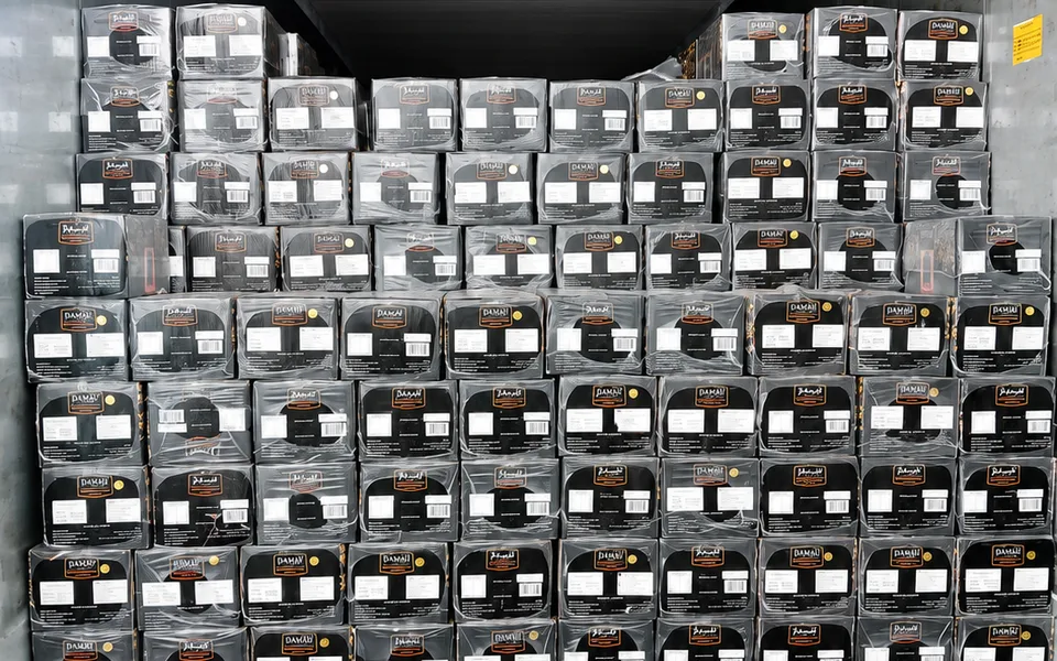 Cartons of dates stacked inside a shipping container ready for delivery